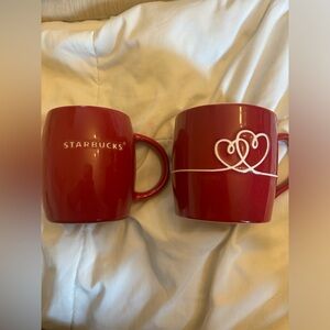 2 red Starbucks mugs